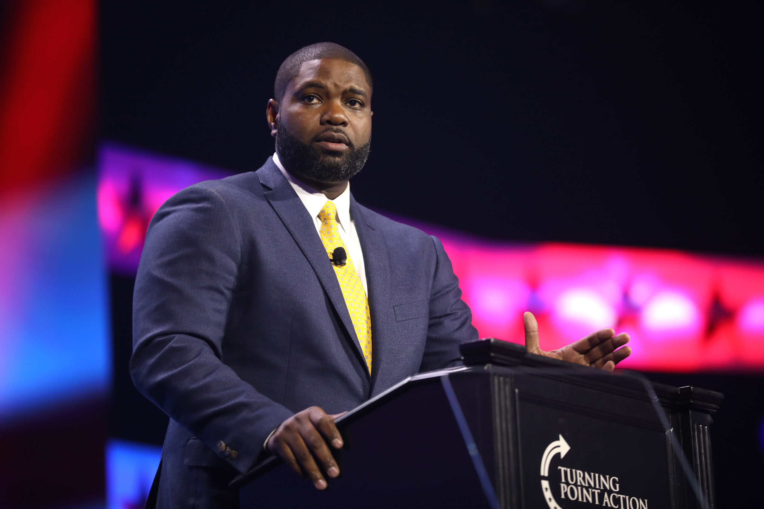 Byron Donalds speaking at a podium at the 2023 Turning Point Action Conference in West Palm Beach, Florida