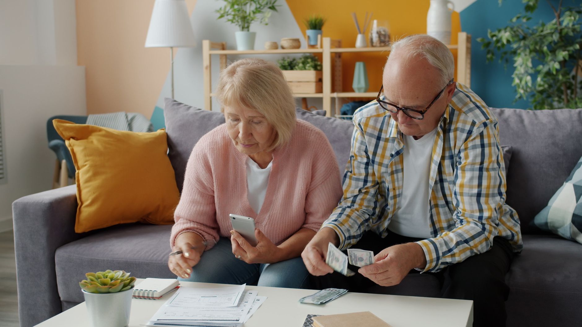 Elderly couple reviewing retirement finances and bills at home