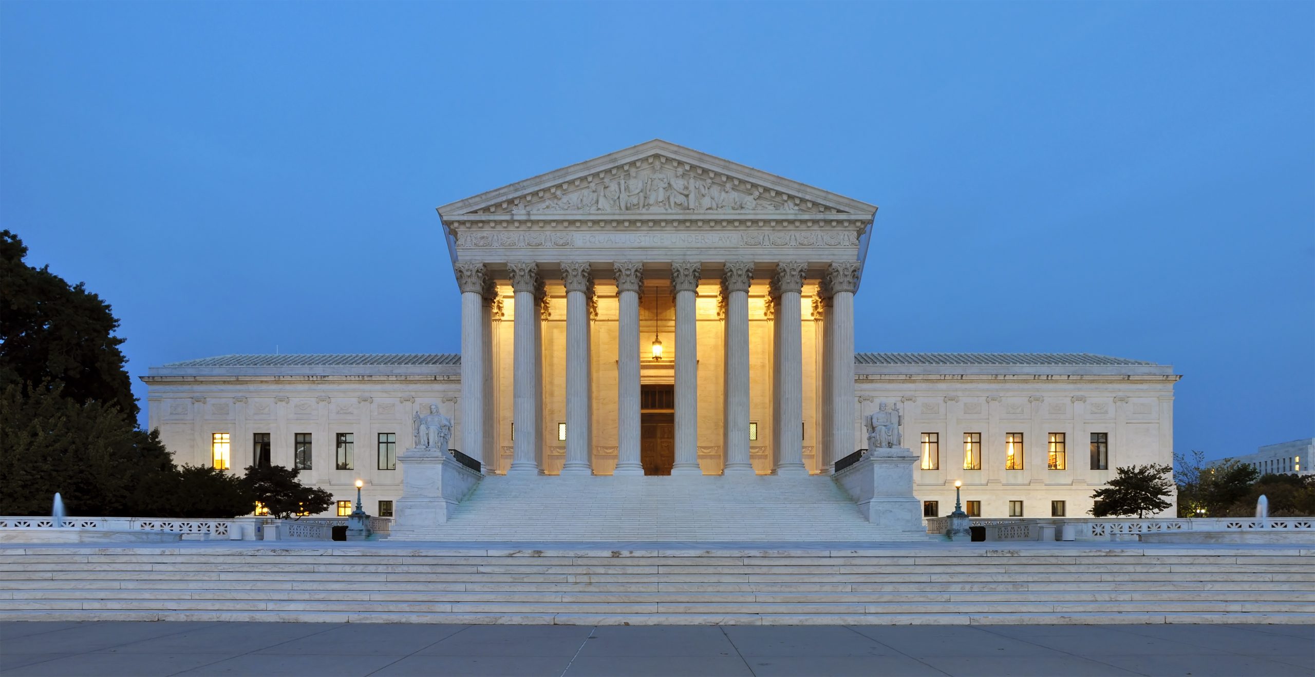 The U.S. Supreme Court building illuminated at dusk