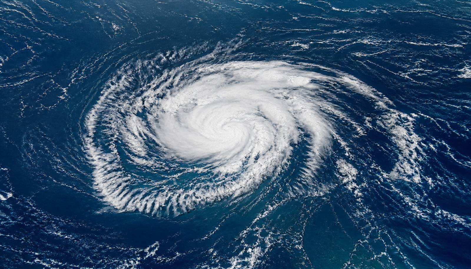 Satellite-style aerial view of a tropical storm swirling over open ocean water