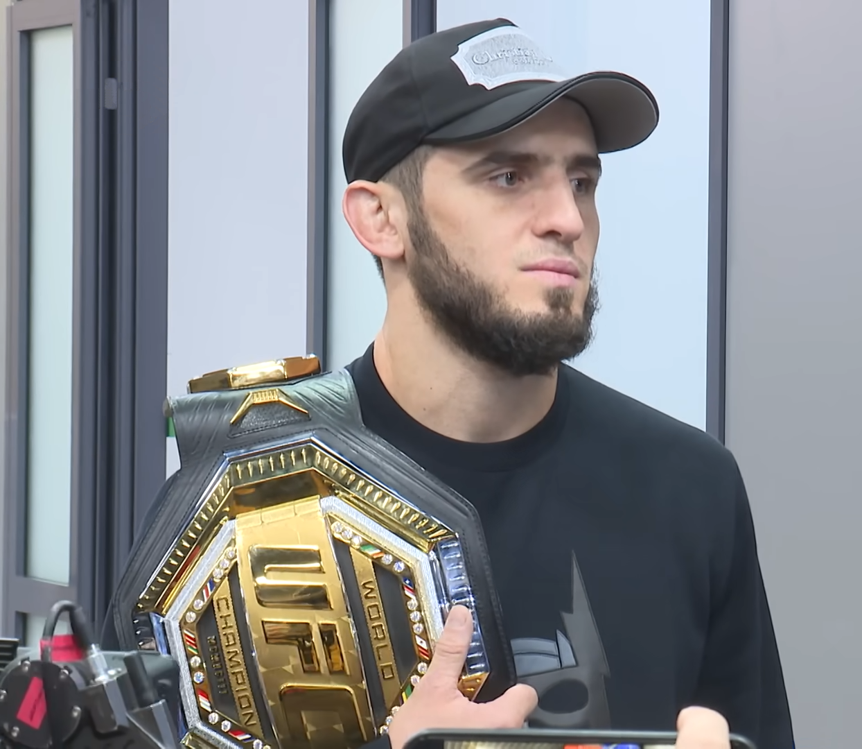 Islam Makhachev holding the UFC lightweight championship belt in 2022 after winning it at UFC 280.