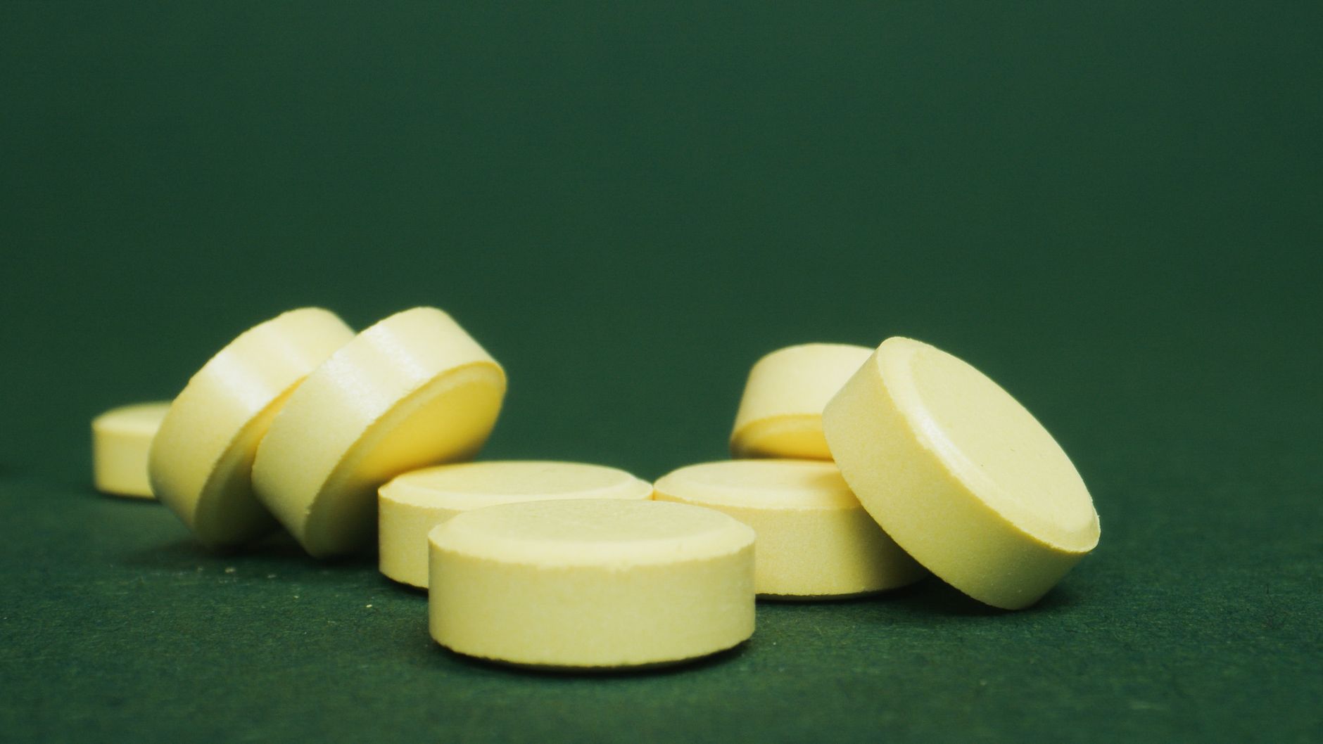 Round yellow thyroid tablets on a green background