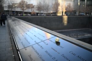 Photo: White rose on engraved names at 9/11 Memorial, poignant tribute to 9/11 victims.