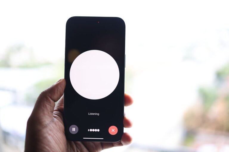 A hand holds a smartphone showing a generic voice-assistant interface in a "Listening" state, illustrating the kind of conversational AI assistant experience Apple's new Siri AI aims to deliver.