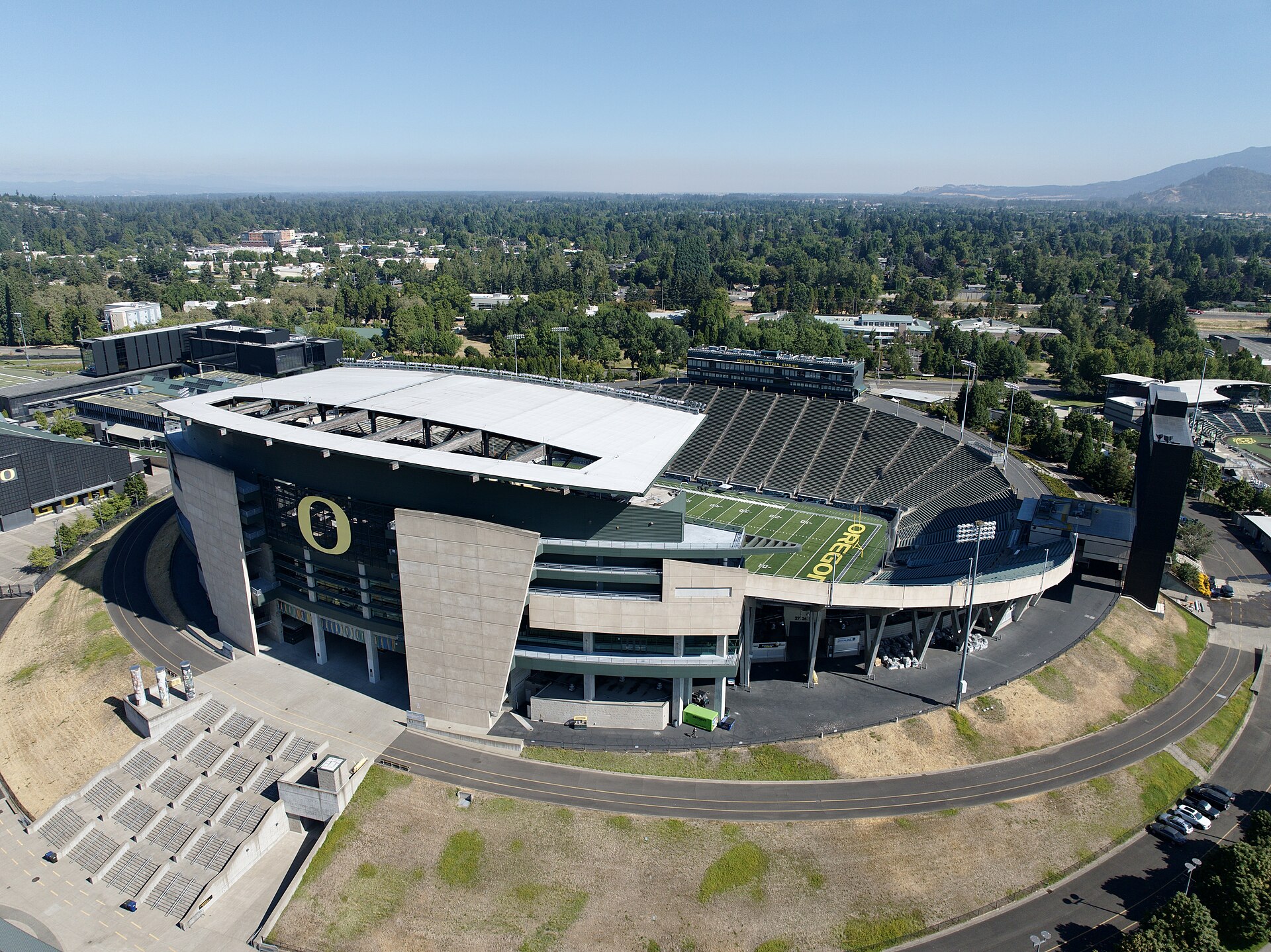 Aerial view of an empty Autzen Stadium in Eugene, Oregon, with a large yellow O on the west grandstand and OREGON painted in the end zone.