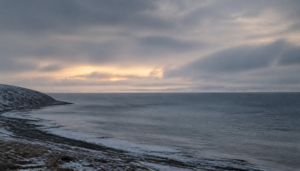 A quiet, overcast Arctic coastal seascape at dusk