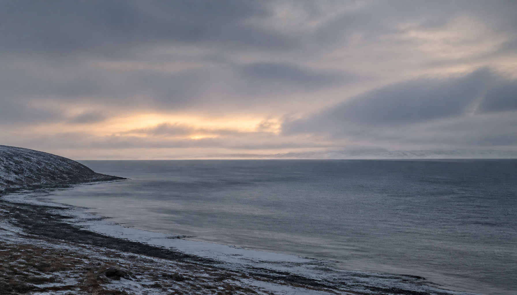 A quiet, overcast Arctic coastal seascape at dusk