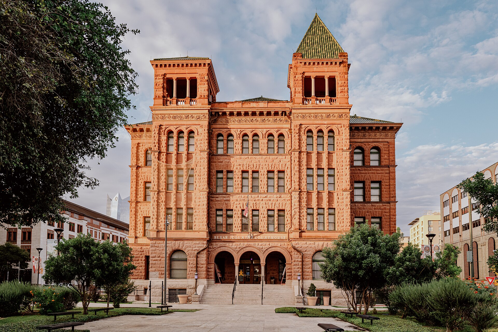 The red sandstone Bexar County Courthouse in downtown San Antonio, Texas, with its two towers and arched entrance.