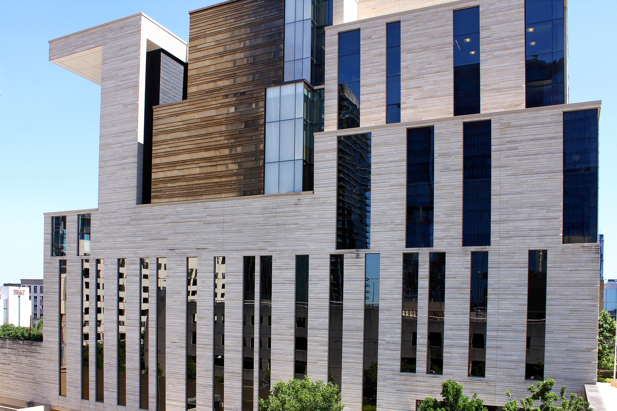 The south side of a modern stone federal courthouse in Austin, Texas, with tall narrow windows reflecting nearby buildings.