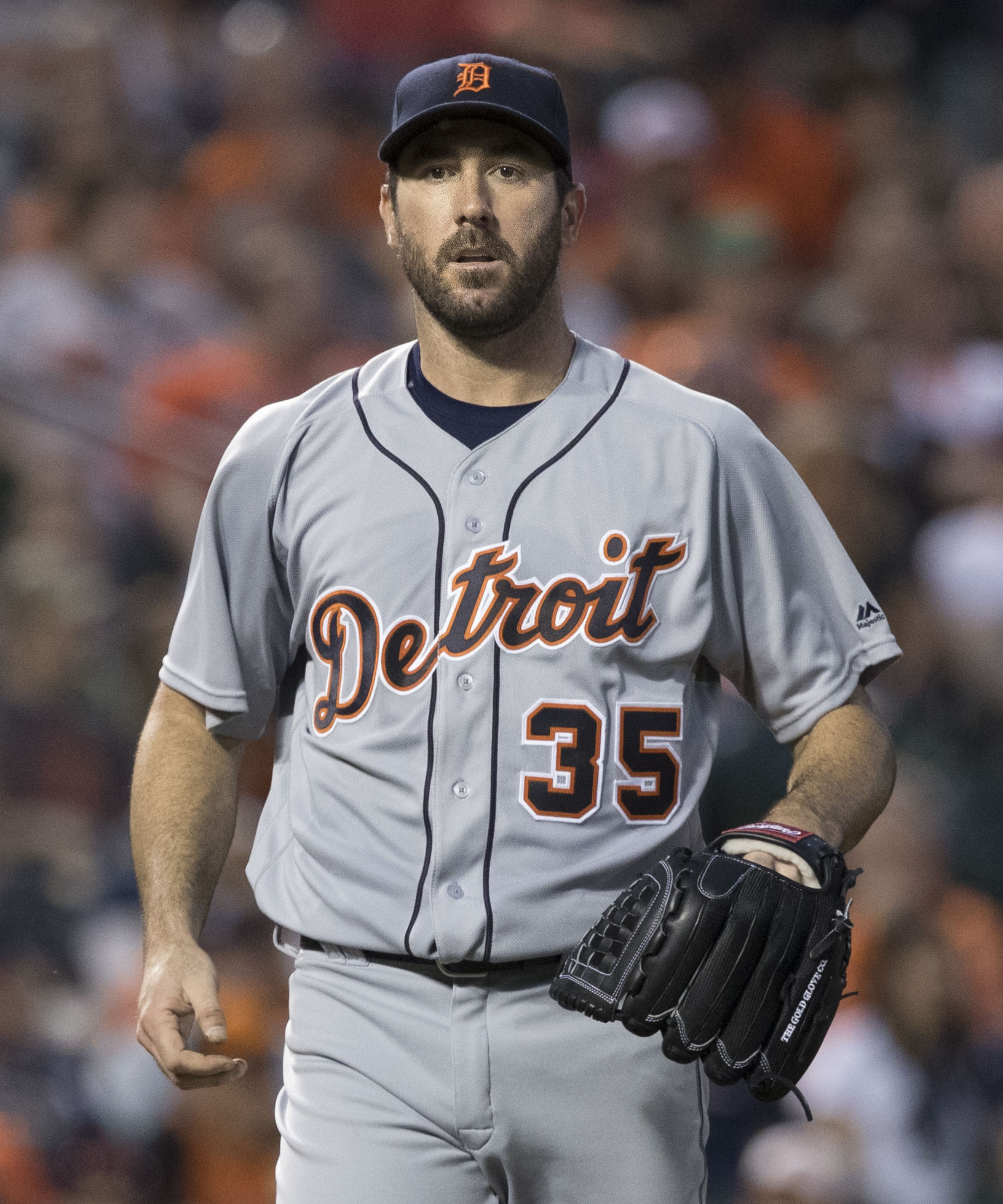 Justin Verlander in a gray Detroit road uniform with the number 35, glove on his left hand, walking on the field.