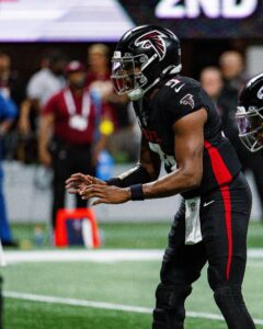 Atlanta Falcons quarterback Michael Penix Jr., wearing No. 9, crouches under center before a snap in a 2025 home game.