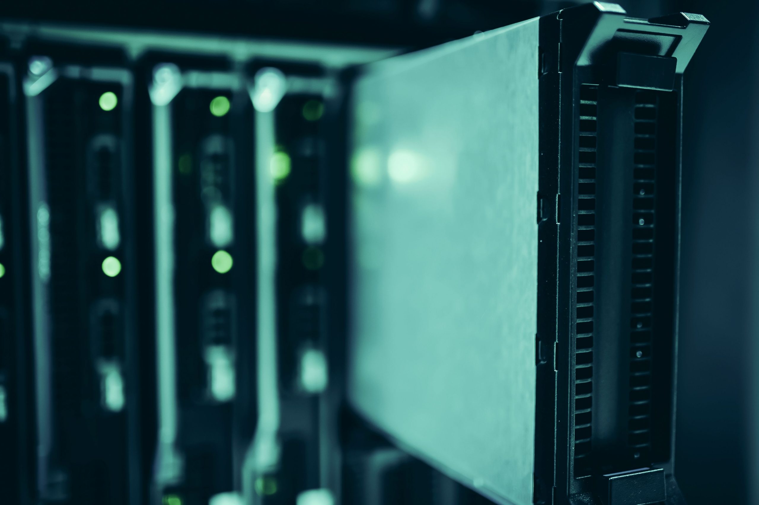 Close-up of active server racks and a hard drive bay in a data center.
