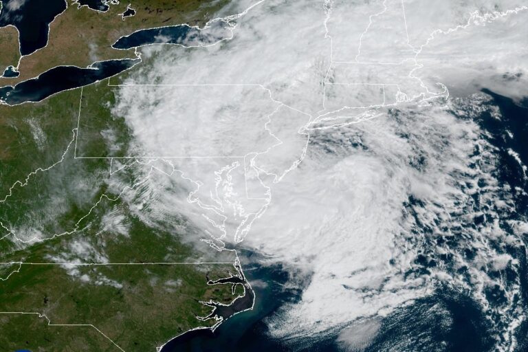 Satellite image of the U.S. Northeast showing a broad white cloud mass from the storm covering New Jersey, New York, southern New England and the Mid-Atlantic coast, with clear skies farther west.