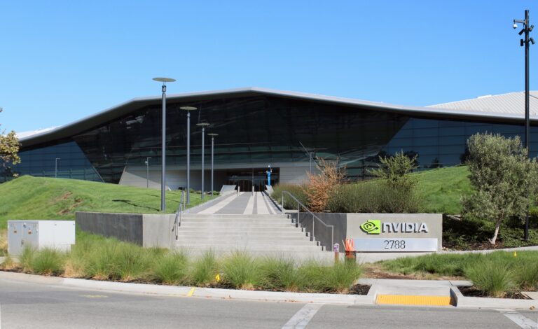 The glass-fronted Nvidia headquarters building in Santa Clara, California, with a landscaped entrance, stairs and an Nvidia sign.