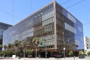 A glass-walled office building at 1515 Third Street in San Francisco's Mission Bay neighborhood, with palm trees and a street corner in front.