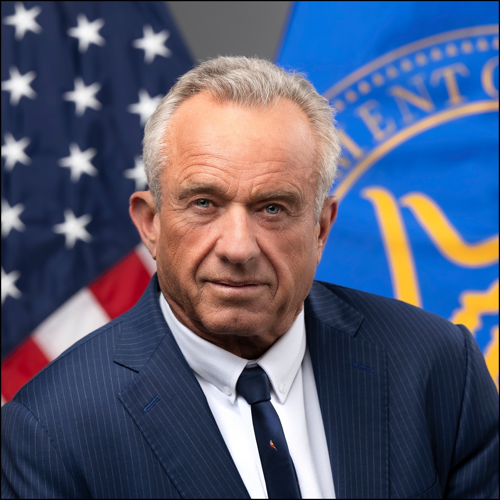 Official 2025 portrait of Health and Human Services Secretary Robert F. Kennedy Jr. in front of the U.S. flag and the HHS flag.