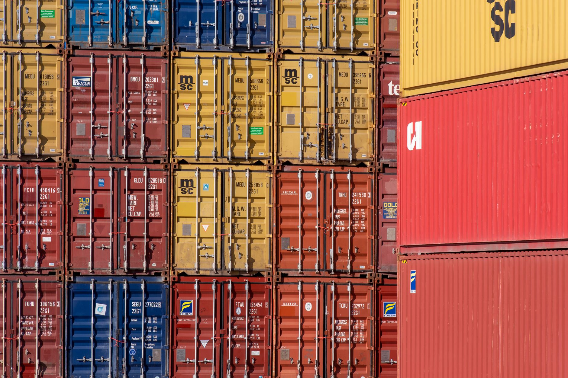 Photo: Colorful shipping containers stacked in a port for transport logistics.