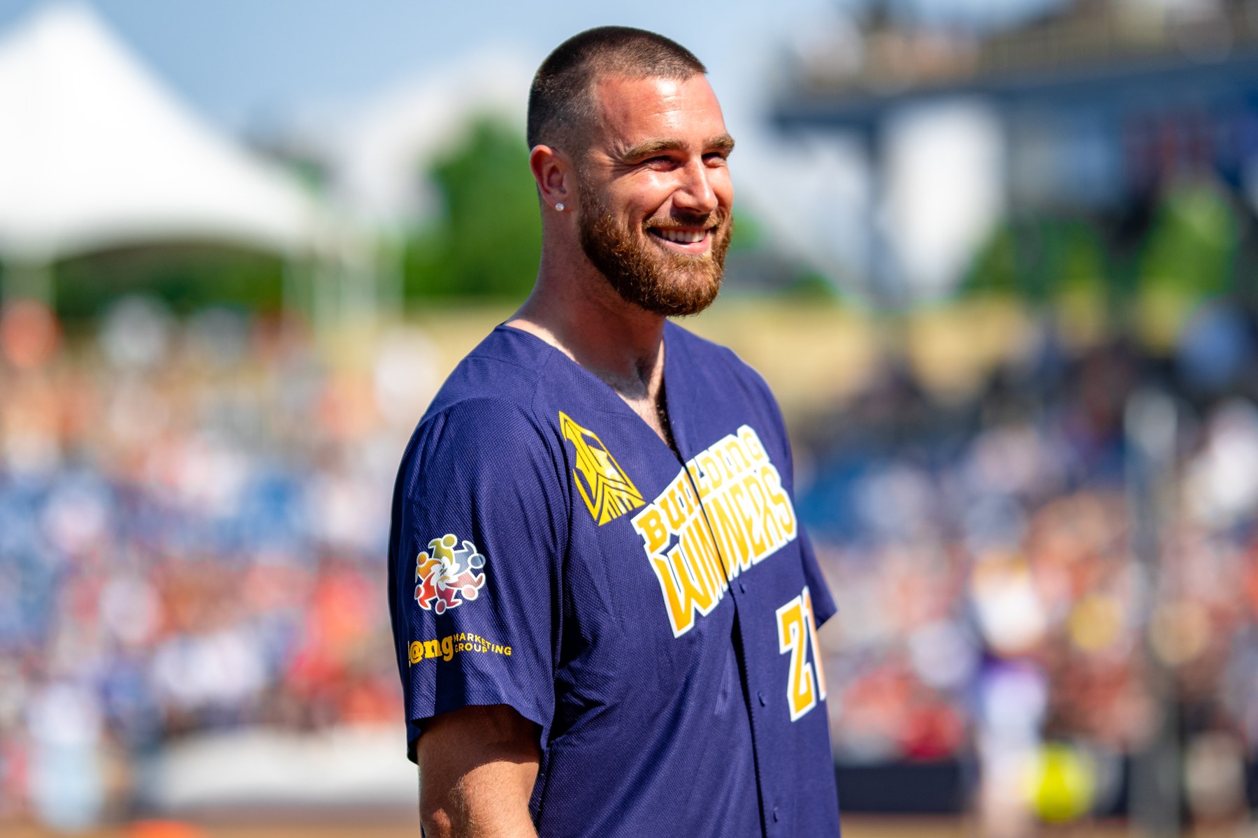Travis Kelce smiling at a charity softball event