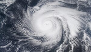 Satellite view of a swirling tropical storm cloud system over open ocean