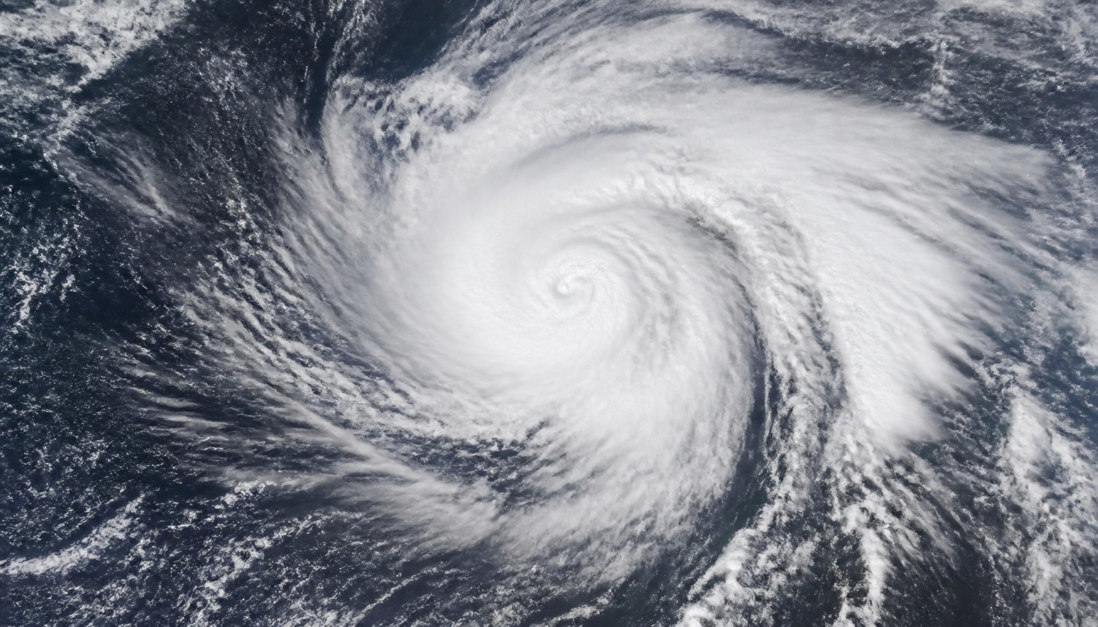 Satellite view of a swirling tropical storm cloud system over open ocean