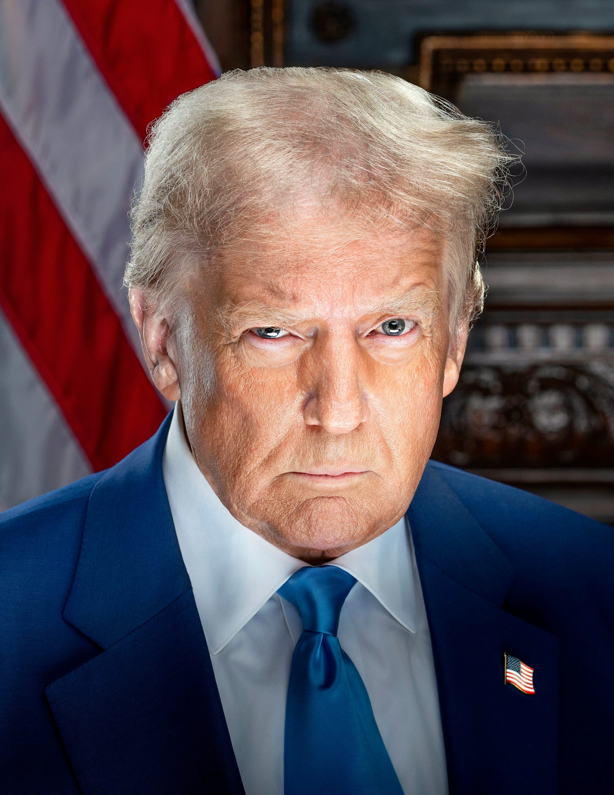 Official portrait of President Donald Trump in a dark suit and blue tie, American flag in background.