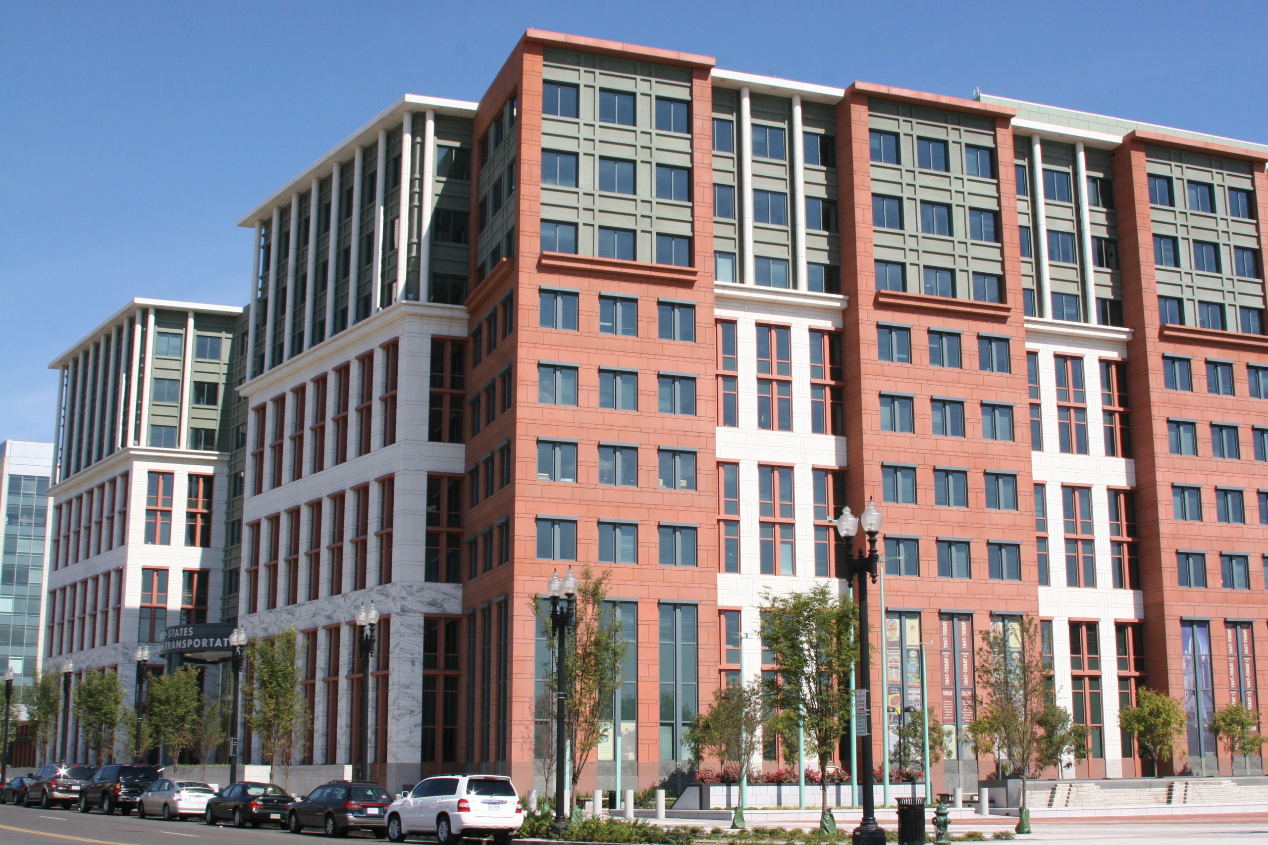 The U.S. Department of Transportation headquarters building in Southeast Washington, a red-and-white stone office block with rows of windows.