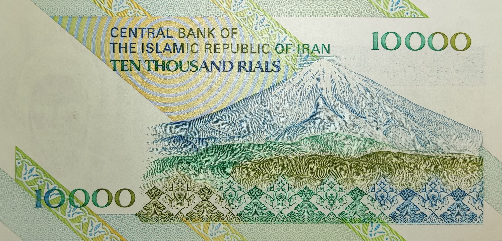 The reverse of an Iranian 10,000-rial banknote, printed 'Central Bank of the Islamic Republic of Iran, Ten Thousand Rials', with an engraved snow-capped mountain.