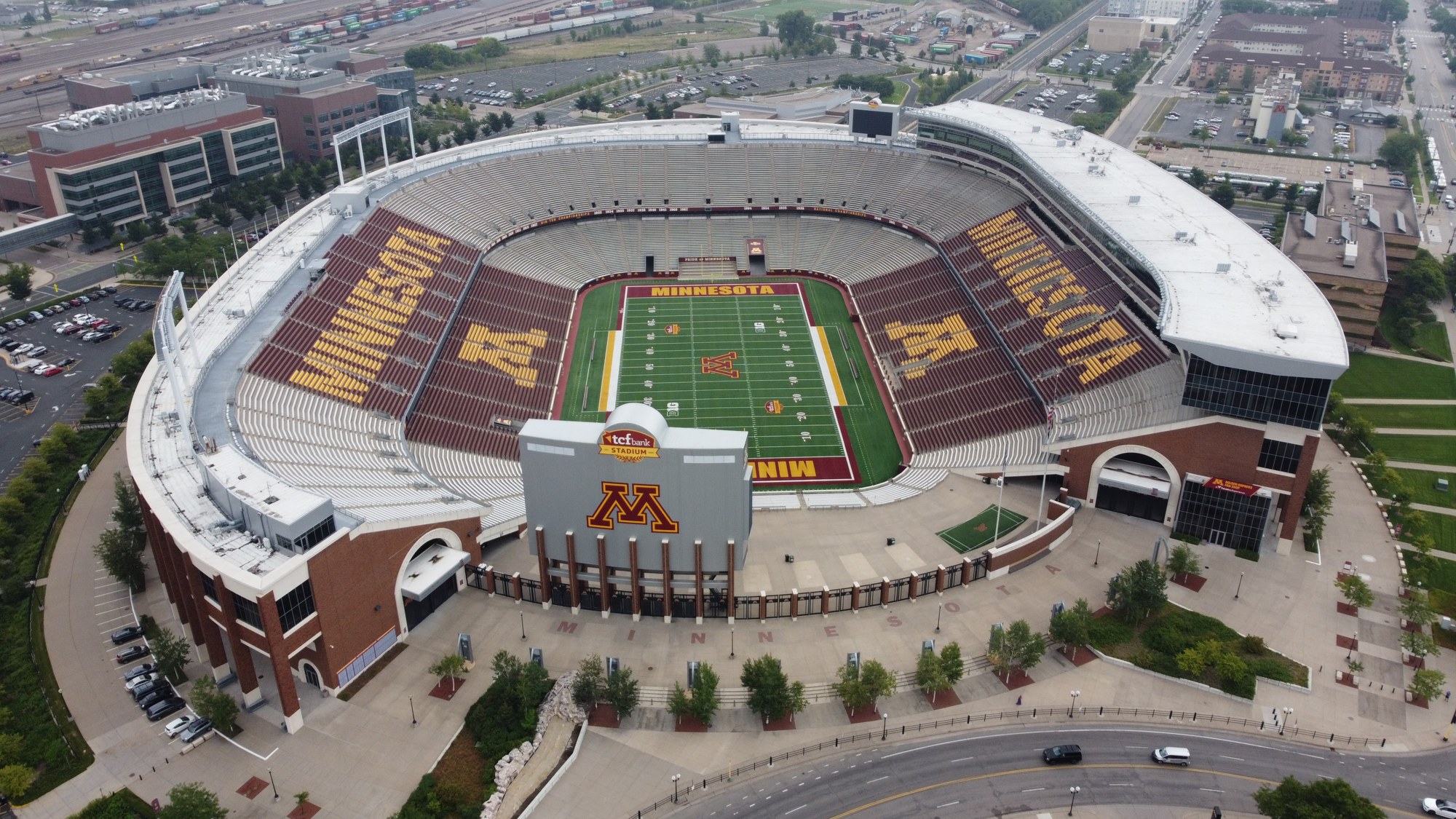 Aerial view of the University of Minnesota football stadium in Minneapolis, with maroon and gold seating spelling Minnesota around an empty field.